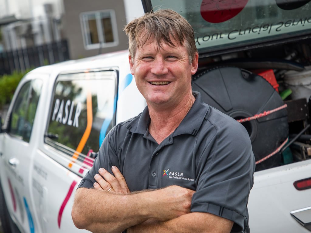 Image description: John Brockelbank, PASLR Pump Technician standing in front of his work van