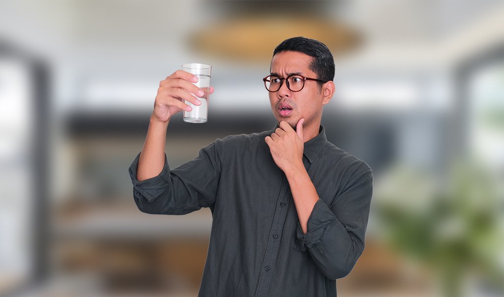 Man examining glass of water